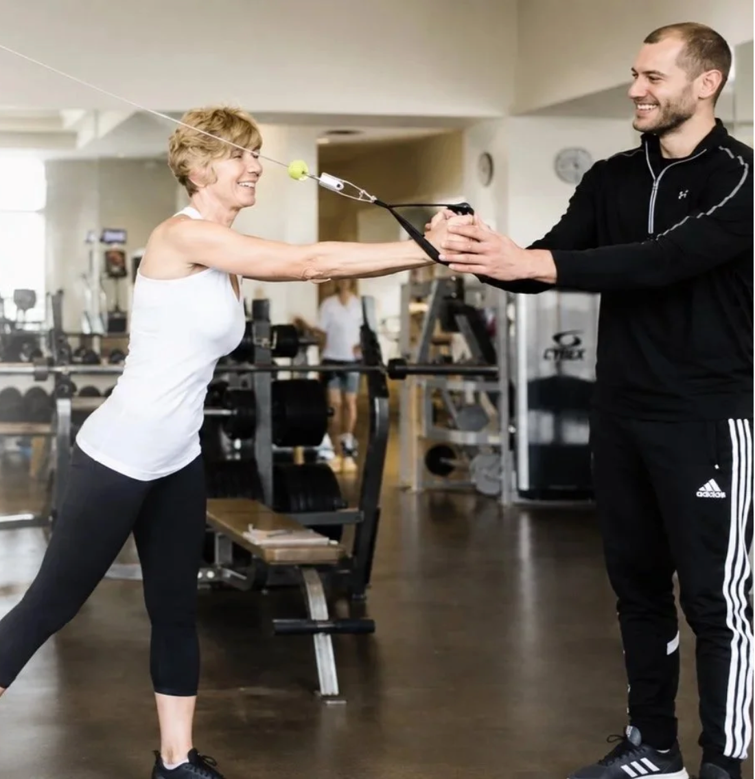 Matthew guiding a client through a standing cable exercise