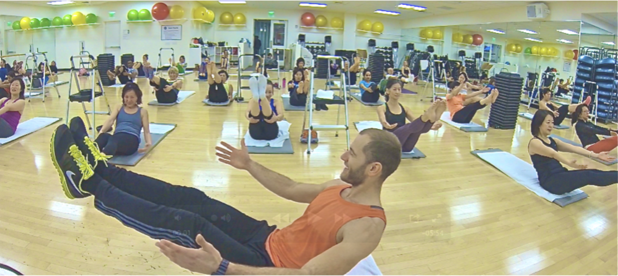 Matthew demonstrating a Pilates exercise at the front of a group mat class